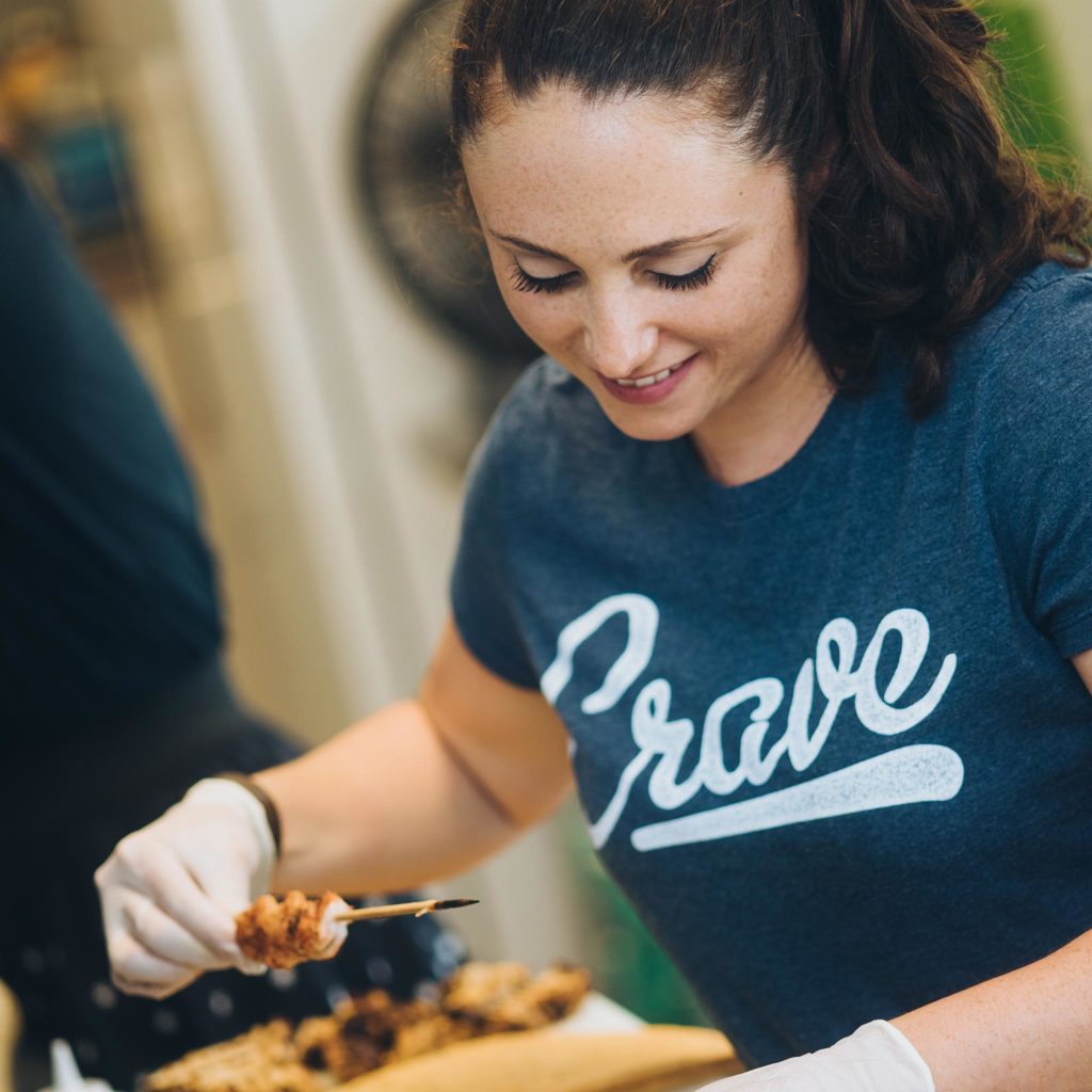 Renee Spadaro, co-owner of Crave Food Truck, preparing a to-go order